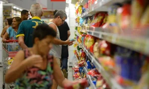 Fotografia colorida mostrando pessoas fazendo compras em supermercado-Metrópoles