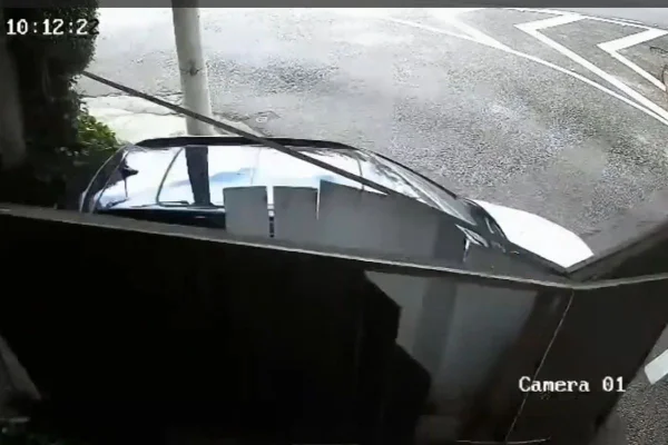 Imagem colorida mostra portão destruído por carro durante fuga de motel. Metrópoles